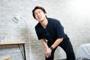 関節を痛そうに押さえる男性の手