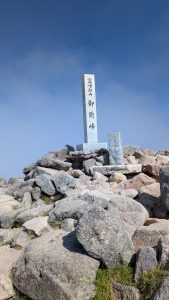白山御前峰山頂の石碑。青空に映える「白山御前峰」の文字が印象的