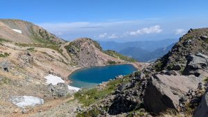 翠ヶ池の美しいエメラルドグリーンの湖面。周囲の山々との調和が絶景